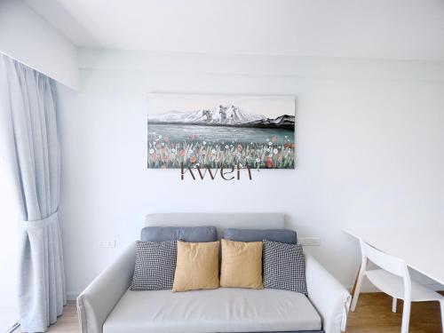 a living room with a couch and a painting on the wall at KWEN Suites-Tanjung Aru InfinityPool Seaview/Airport View in Kota Kinabalu