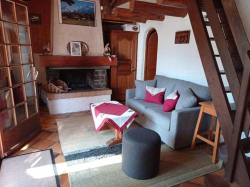 a living room with a couch and a fireplace at Chalet Chez Nous in Domancy