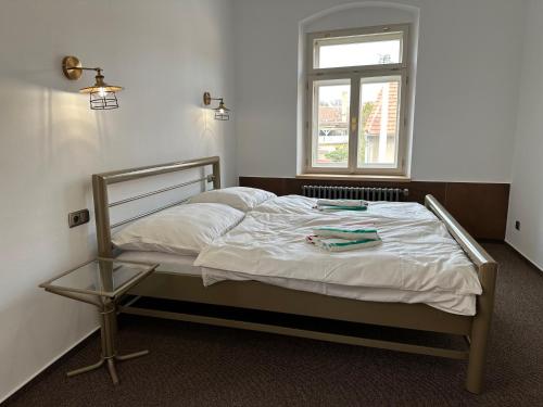 a bed in a room with a window at VAPARTMANY in Plumlov