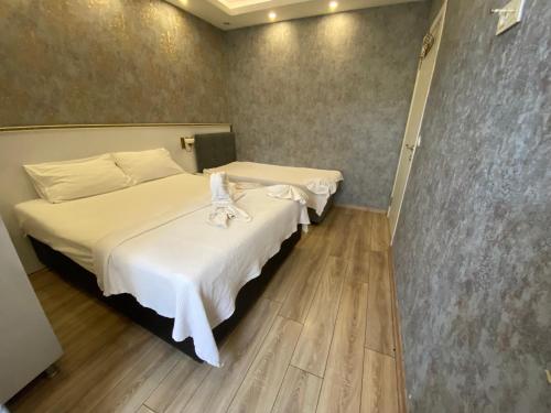 a hotel room with two beds with white sheets at SİSLİ EV 2 in Istanbul