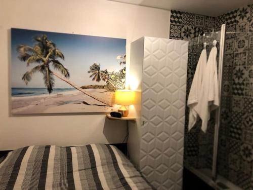 - une chambre avec un lit et une photo de la plage dans l'établissement Appartement à 250m de la mer, à Saint-Raphaël