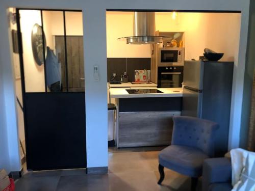 une cuisine avec une chaise bleue et une cuisinière four supérieur dans l'établissement Appartement à 250m de la mer, à Saint-Raphaël