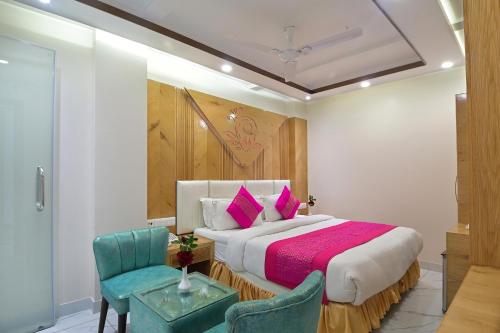 a bedroom with a large bed and two chairs at Aman International-A New Unit of Aman Continental in New Delhi