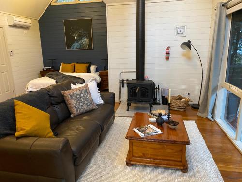 a living room with a couch and a stove at Two Truffles Cottage Accommodation in Yarra Glen