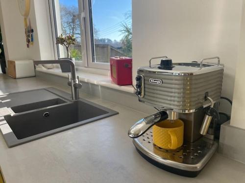 a mixer sitting on a kitchen counter next to a sink at Stunning, Modern and Spacious House - Truro in Truro