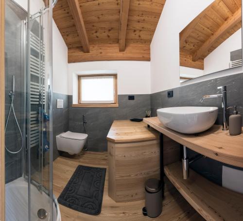 een badkamer met een wastafel en een glazen douche bij La cà del Bisun in Colico