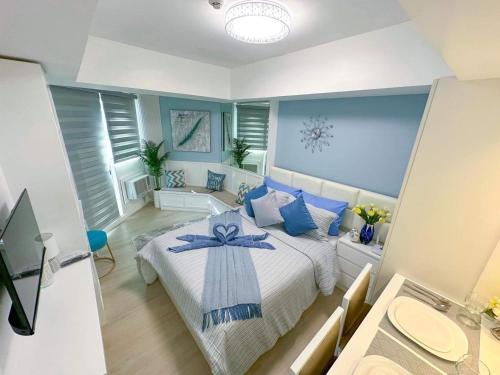 サンフェルナンドにあるLA CASA ALEYKA AZURE NORTH PAMPANGA BALI Tower 518の青い壁のベッドルーム1室(大型ベッド1台付)