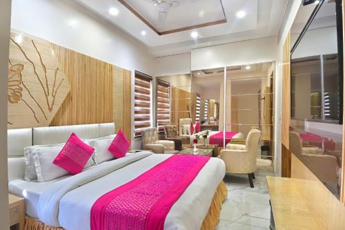 a bedroom with a large bed with pink pillows at Aman International-A New Unit of Aman Continental in New Delhi