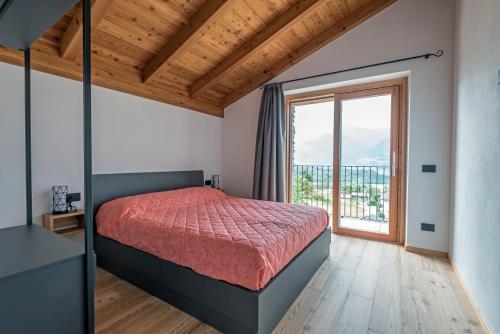 a bedroom with a bed and a large window at La cà del Bisun in Colico