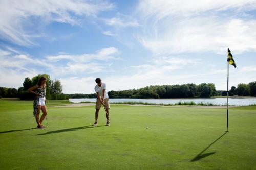 zwei Personen spielen eine Partie Golf auf einem Golfplatz in der Unterkunft Cottages et B&B de Troussay in Cheverny