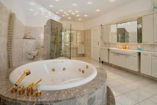 a large bathroom with a tub and a sink at Villa Merle mit privatem Indoorpool in Rühn