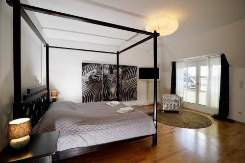 a bedroom with a bed with a painting of a zebra at Villa Merle mit privatem Indoorpool in Rühn