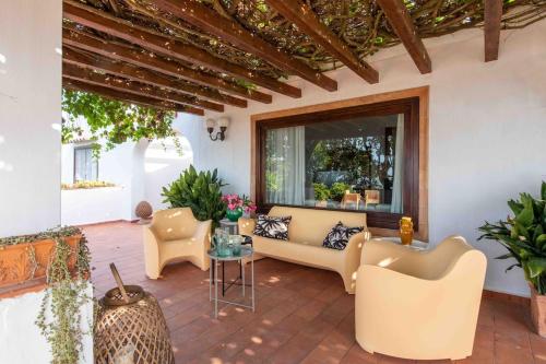 a patio with a couch and chairs and a window at Villa Grimodi in Caronia Marina