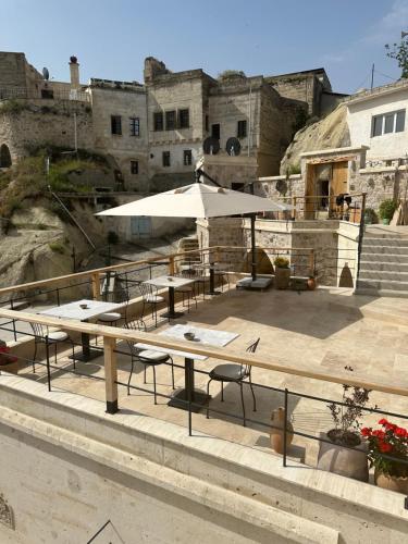 a patio with tables and umbrellas in front of a building at Vie Cappadocia - Adults Only in Nevşehir