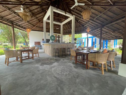 a restaurant with tables and chairs and a bar at Blue EmOcean Dive Resort in Moyo Island
