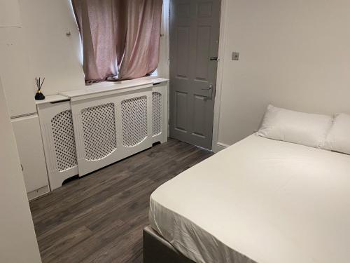 a bedroom with a white bed and a window at The lovely apartment in London