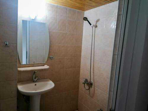 uma casa de banho com um lavatório e um chuveiro com um espelho. em Paşa Restaurant & Pansiyon em Kemer
