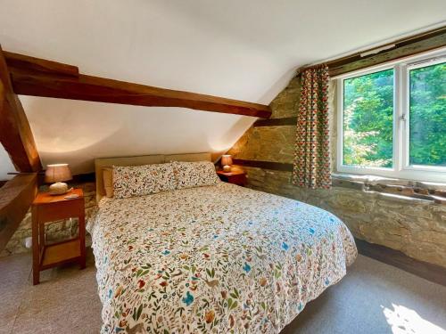 1 dormitorio con cama y ventana en Stable Cottage, en Leintwardine