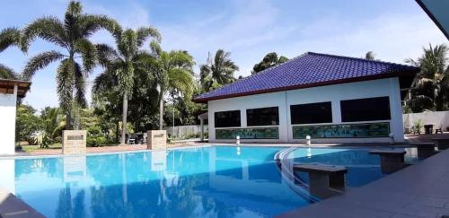 a swimming pool with a house and palm trees at DamaiSari Tawang in Bachok