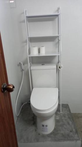 a bathroom with a white toilet in a room at Billabong Hotel and Cafe in Baan Tai
