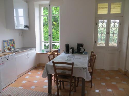 une cuisine avec une table et des chaises et une cuisine avec des fenêtres dans l'établissement Villa Crozon 6 à 8 pers vue mer, à Crozon