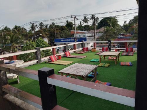 a group of picnic tables on a field of grass at Billabong Hotel and Cafe in Baan Tai