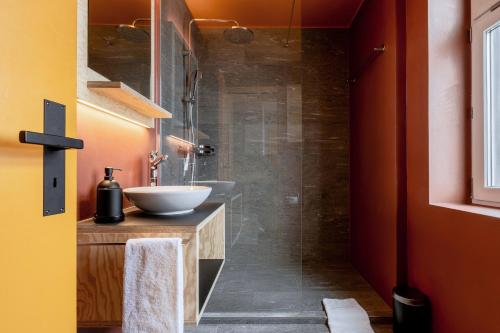 ein Bad mit einem Waschbecken und einer Glasdusche in der Unterkunft Belmont- Apartment Haus in Arosa