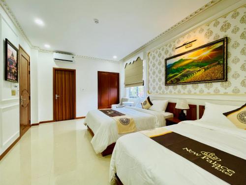 a hotel room with two beds and a painting on the wall at NEW PALACE HOTEL in Quang Ngai
