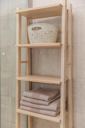 a wooden shelf with towels and a bowl on it at Apartment Vengust in Malinska