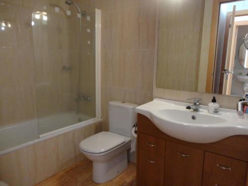 a bathroom with a toilet and a sink and a shower at Alba in Sant Feliu de Guíxols