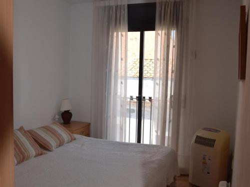 a bedroom with a bed and a large window at Alba in Sant Feliu de Guíxols