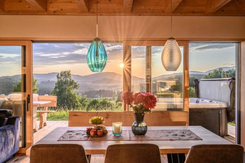 a dining room with a table and a large window at Kroner Chalets in Zwiesel