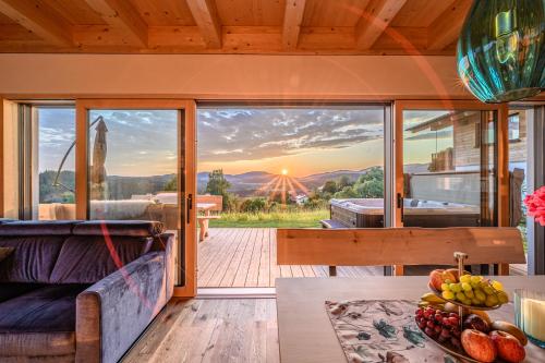 a house with a view of the sunset from the living room at Kroner Chalets in Zwiesel