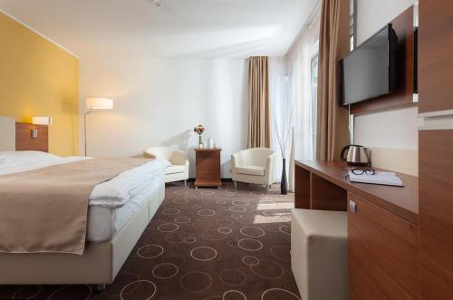 a hotel room with a bed and a flat screen tv at Wellness Hotel Panorama in Trenčianske Teplice