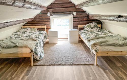 two beds in a room with wooden walls at Amazing Home In Gyttorp With Wifi And 3 Bedrooms in Gyttorp