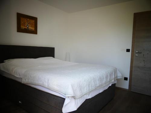 1 dormitorio con 1 cama con sábanas blancas y puerta en VISTA apartma, en Izola