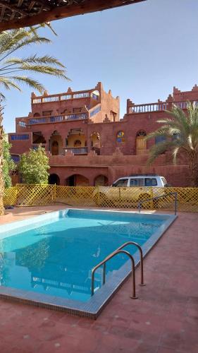 une grande piscine en face d'un bâtiment dans l'établissement Maroc Galacx, à Ouarzazate