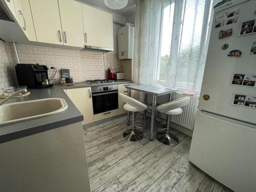 uma cozinha com um frigorífico branco e uma mesa com bancos em Ary apartments em Ocna-Mureşului