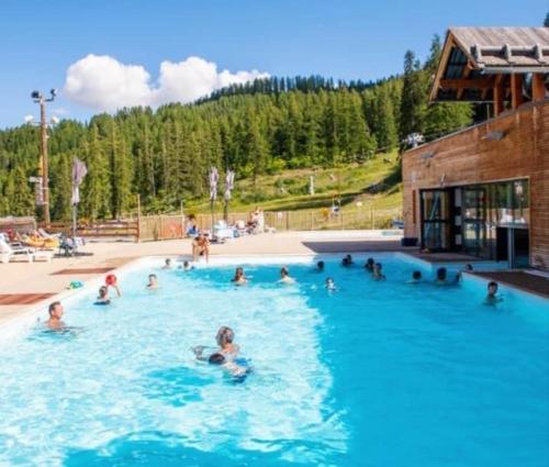 a group of people swimming in a swimming pool at Appartement 4 personnes Puy St Vincent 1700 in Puy-Saint-Vincent