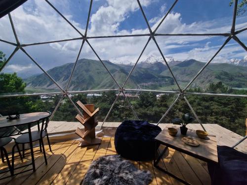 a room with a large glass dome with a table and chairs at Elia Glamping in Stepantsminda