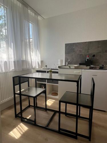 a kitchen with a table and two chairs in it at Modernes Apartment in Bad Kreuznach mit einfachem Self-Check-in in Bad Kreuznach