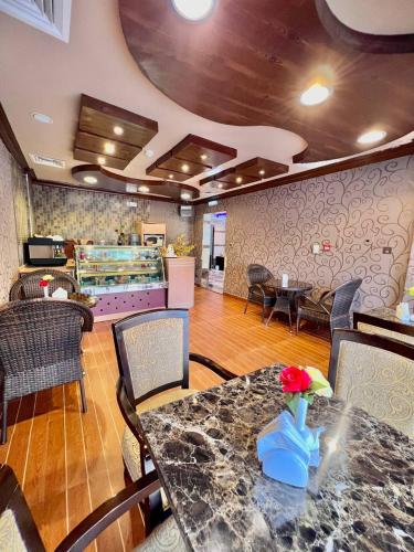 a restaurant with a table and chairs and a counter at Dream Palace Hotel in Ajman 