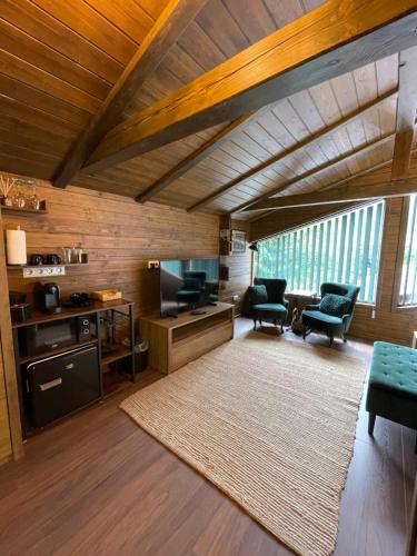 a large living room with wooden ceilings and a large rug at Hétvezér Panzió in Sub Cetate