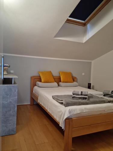 - une chambre avec un lit et des oreillers jaunes dans l'établissement Appartments D&D, à Peroj