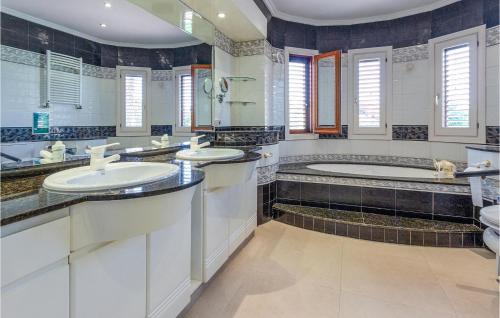 a bathroom with two sinks and a tub at Lovely Home In Elche With Kitchenette in Elche