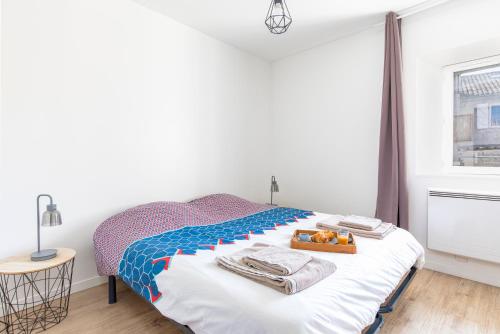 1 dormitorio con 1 cama y bandeja de toallas en WhiteHorse 2 CahorsCityStay en Cahors