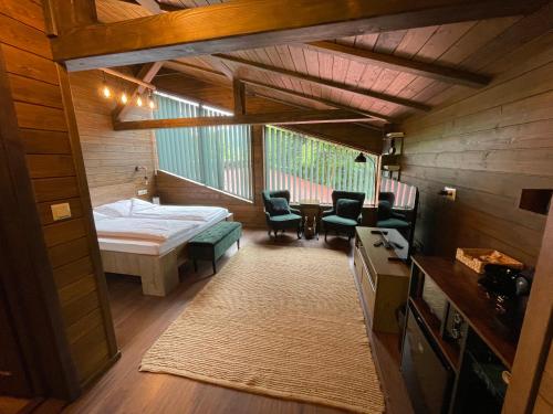 a small room with a bed and a table and chairs at Pensiunea Hétvezér Panzió in Sub Cetate
