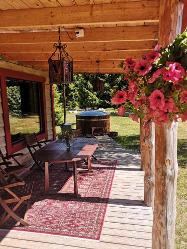 a wooden patio with a table and a grill at Metsaräägu Wellness in Ulendi