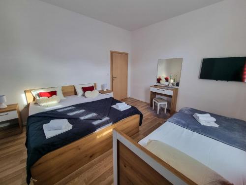 a room with two beds and a tv on the wall at Villa Danijela in Janjina