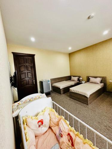 a hotel room with two beds and a balcony at Liel in Tbilisi City